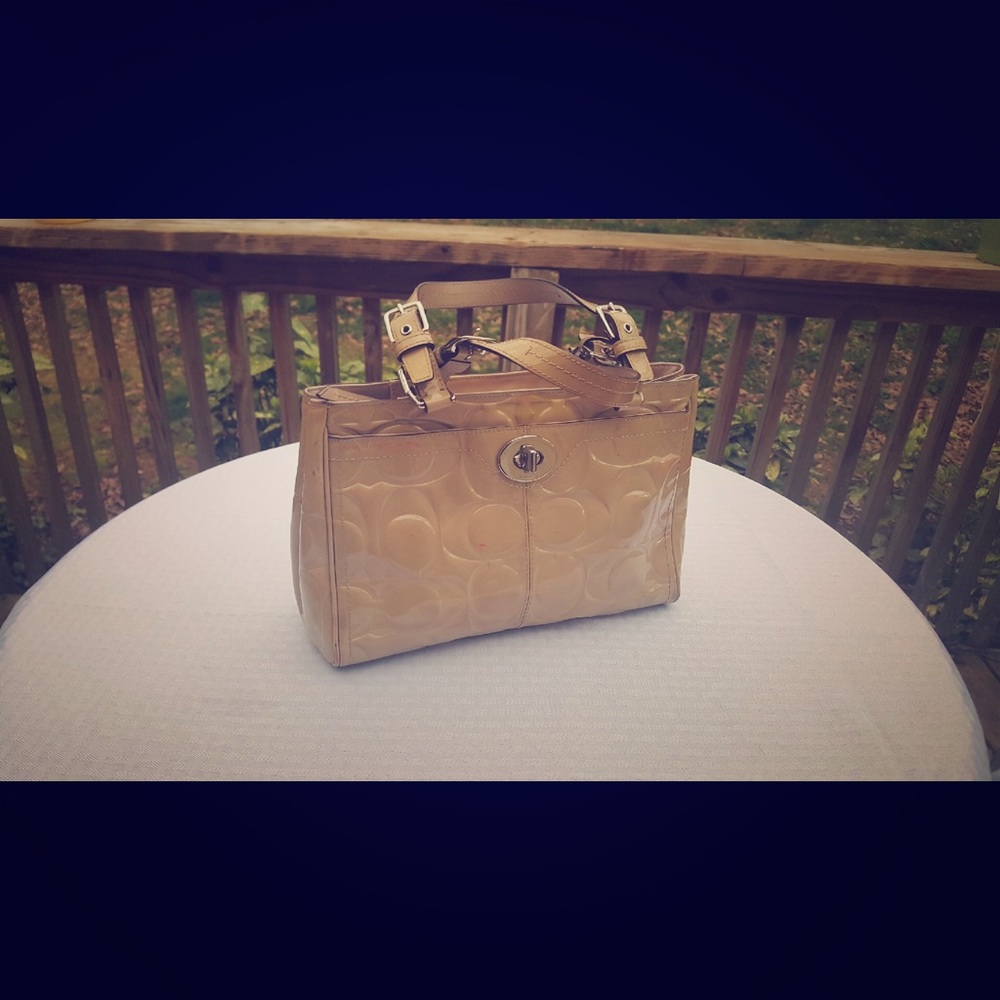 Cream coach patent leather bag.
